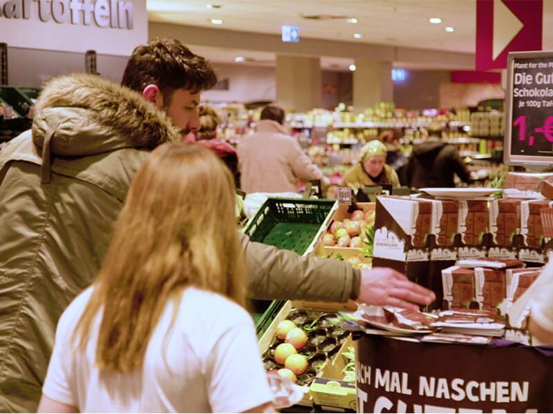 Mann nimmt im Supermarkt eine Tafel Schokolade